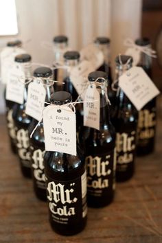 many black bottles with labels on them sitting on a table