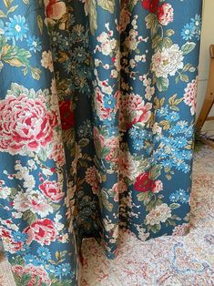 a blue floral curtain with red and white flowers on it