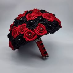 a red and black wedding bouquet on a gray background