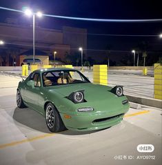 a green car parked in a parking lot at night