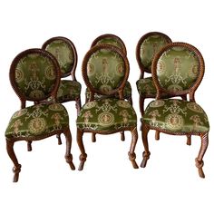 four chairs with green and gold upholstered fabric