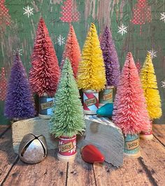 small tinsel christmas trees in cans on a wooden table