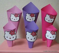 three paper cones with hello kitty on them sitting on a pink table next to each other