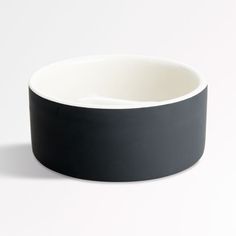 an empty black and white bowl on a white background