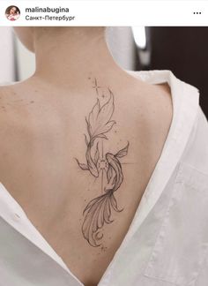 the back of a woman's neck with a goldfish tattoo on her left side