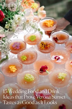 a table topped with lots of glasses filled with drinks and flowers on top of it