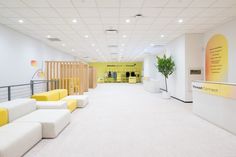 an office lobby with yellow and white furniture