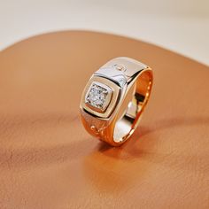 a diamond ring sitting on top of a wooden table next to a brown leather surface