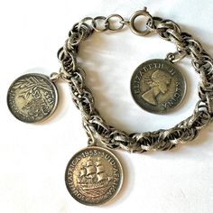 Vintage Coin Bracelet, Silver Triple Cable Bracelet Signed Germany, Queen Elizabeth S Africa Coins, French Republic Coin, 1950s Coin Jewelry Wonderful vintage coin bracelet. Silver tone textured triple cable chain link bracelet signed Gemany with two Queen Elizabeth ll, South Africa Coins, 1953. The last coin is French Republic 1955. the same on the front and back. Nice starter bracelet. 7 3/4" x 3/8".  Wonderful vintage condition.   More Coin Jewelry https://www.etsy.com/shop/VintageVogueTreasure?ref=hdr&search_query=coin Reine Elizabeth Ii, Cable Bracelets, Coin Bracelet, Coin Jewelry, Bracelet Silver, Elizabeth Ii, Chain Link Bracelet, Queen Elizabeth, Silver Bracelets