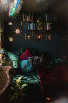 a bed with lots of pillows on top of it next to a book shelf filled with books