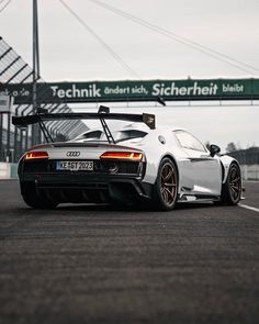 a white sports car driving down a race track