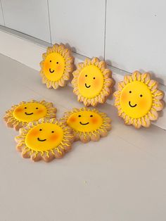 cookies decorated with sunflowers and smiling faces are on the floor next to each other