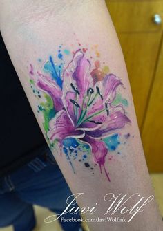 a watercolor style flower tattoo on the arm