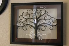 a family tree is hanging on the wall in front of a framed sign that reads, love