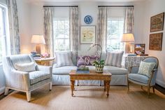 a living room filled with furniture and two lamps on either side of the couches