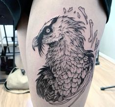 a black and white bird tattoo on the thigh