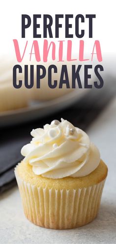 a cupcake with white frosting sitting on top of a table