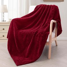 a red blanket sitting on top of a wooden chair