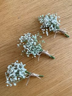 three small bouquets of baby's breath on a table