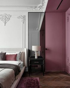 a bedroom with pink walls and wood floors