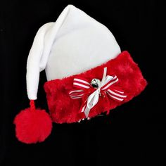 "Classic styling in a novelty Santa costume hat made up in a cozy white poly fleece with a Christmas red faux fur turn up brim. There is a fluffy red faux fur dangle pompom stitched on the tip and a candy cane ribbon tied jingle bell accent on the red fur brim. Proportions of the hat are generous and will fit most head sizes, ladies or gents in a relaxed slouch fit.  Measurement for opening for your head is 24-25\" circumference and the length is 20\". Check measurements to make sure this size w Santa Costume, Red Fur, Santa Claus Hat, White Fleece, Christmas Celebration, Jingle Bell, Costume Hats, Party Hat, Christmas Red