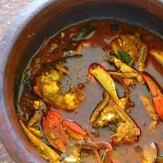 a pot filled with lots of food on top of a wooden table