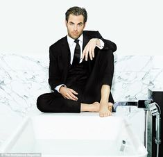 a man in a suit sitting on top of a bath tub