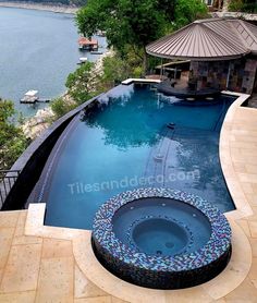 an above ground swimming pool surrounded by stone steps and a gazebo overlooking the water