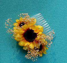 a sunflower and baby's breath comb on a blue surface