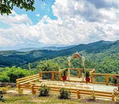 an outdoor ceremony setup with flowers and greenery in the foreground, surrounded by mountains