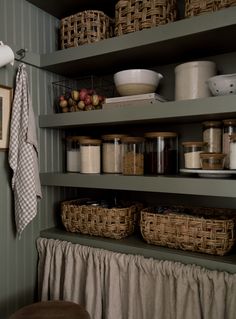 the shelves in this kitchen are filled with baskets and other things to put on them