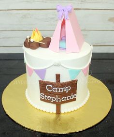 a cake with a tent on top and a sign that says camp steephamie