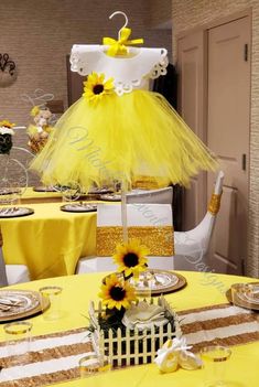 a yellow table cloth with sunflowers on it and a cake in the center