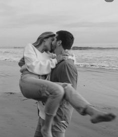 a man carrying a woman on his back at the beach