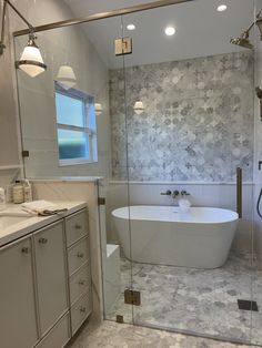 a white bath tub sitting inside of a bathroom next to a walk in shower stall