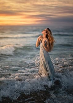 a woman is standing in the ocean water