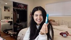 a woman holding up a toothbrush in her hand