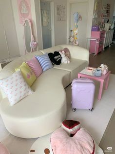 a living room filled with white furniture and lots of pink accessories on top of it