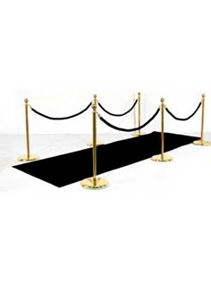 a black carpet with gold poles and rope barriers on white background for an award ceremony