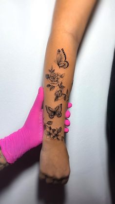 a woman's arm with butterflies and flowers on it