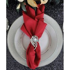 a red napkin is wrapped around the edge of a white plate with flowers on it