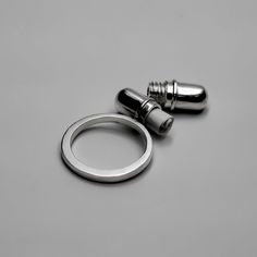 two stainless steel hose clamps sitting on top of a gray table next to each other