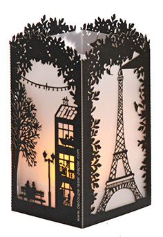 a lit up lantern with the eiffel tower in the background