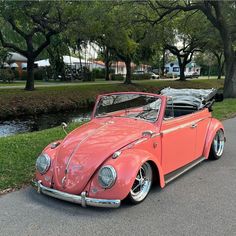 an old red car is parked on the side of the road