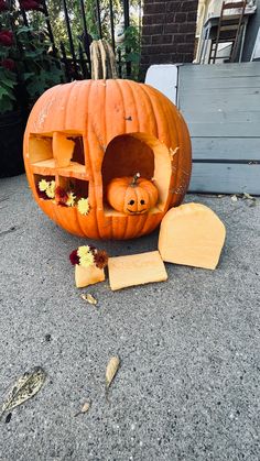 a carved pumpkin sitting on the ground next to some slices of cheese and other items