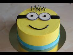 a birthday cake with a yellow and blue frosting decorated as a minion face