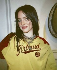 a woman wearing a yellow shirt and necklace