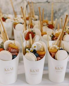 small cups filled with different types of food on top of a white table covered in strawberries