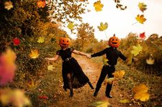 two children dressed up as jack - o'- lanterns running down a dirt road