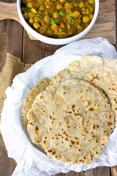 three tortillas sitting on top of a white plate next to a bowl of salsa